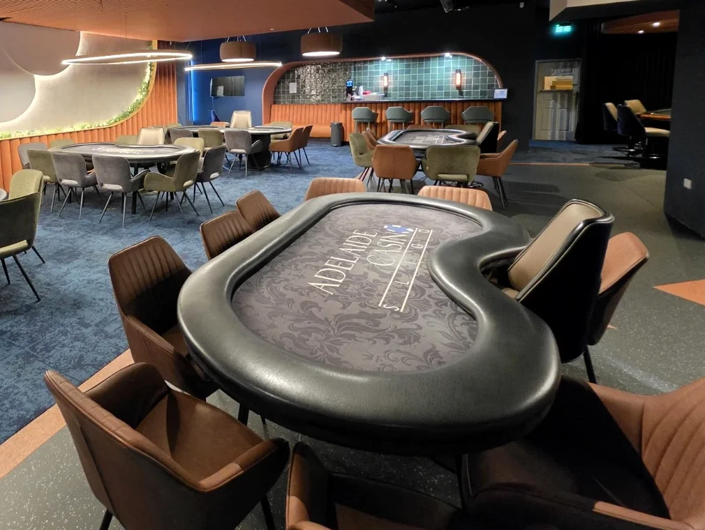 Close-up of an Adelaide Casino poker table with the Adelaide branding and upholstered seating